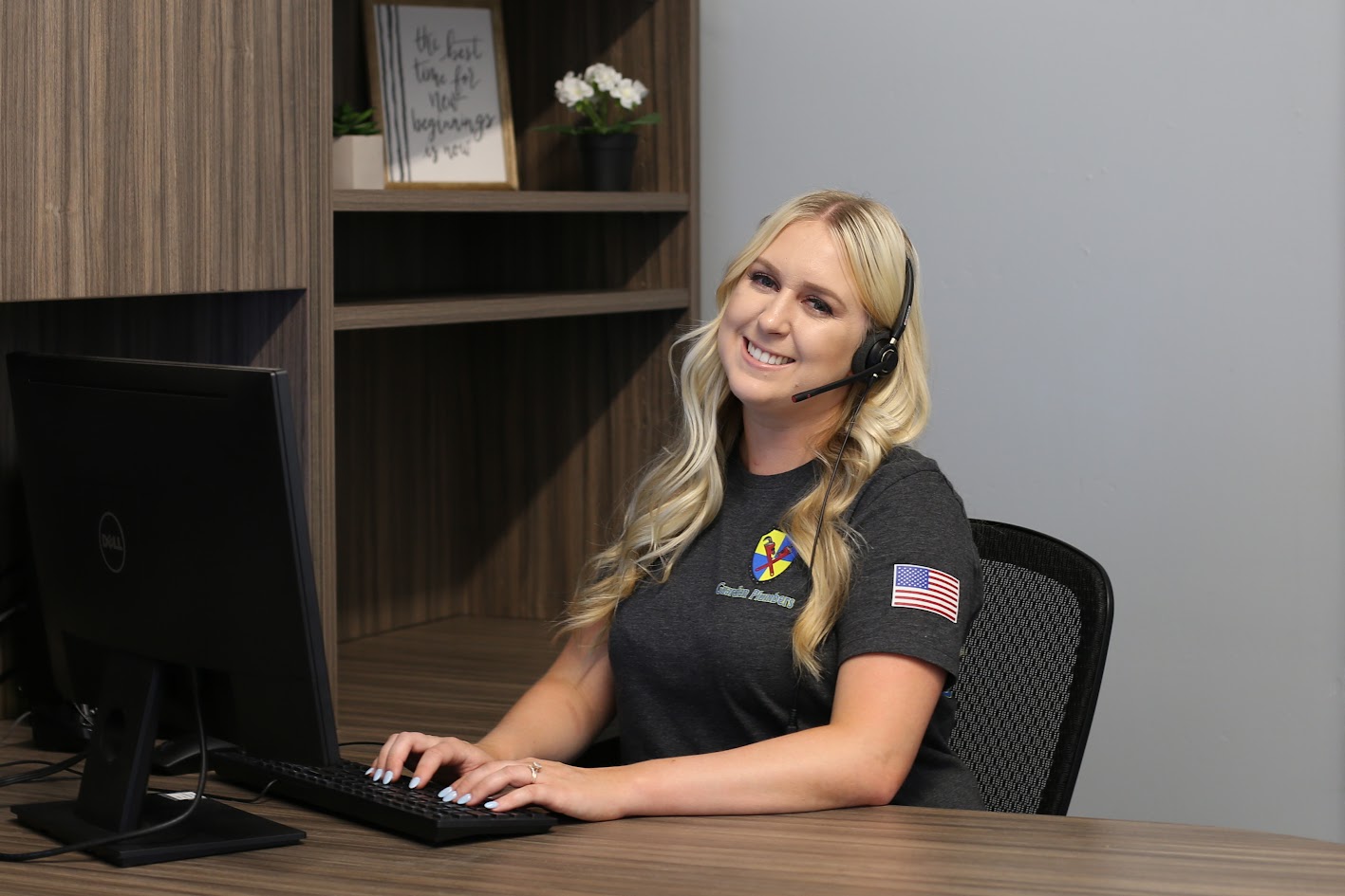 A cheerful customer representative for Guardian Plumbers is seen answering the phone, her warm smile conveying friendliness and professionalism. The inviting atmosphere reflects the company's commitment to excellent customer service and support.