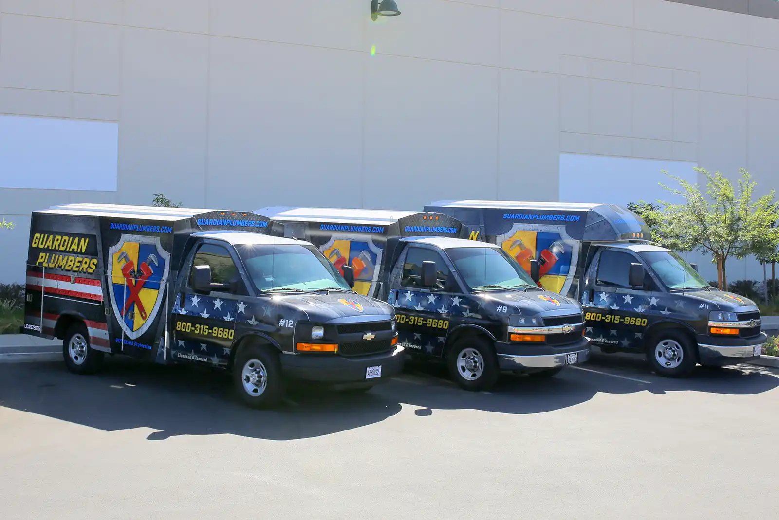 Three Guardian Plumbers service and repair vehicles are parked side by side, each prominently displaying the company logo. The well-maintained fleet, showcasing uniform branding and professional appearance, underscores the reliability and readiness of Guardian Plumbers to tackle any plumbing challenge.